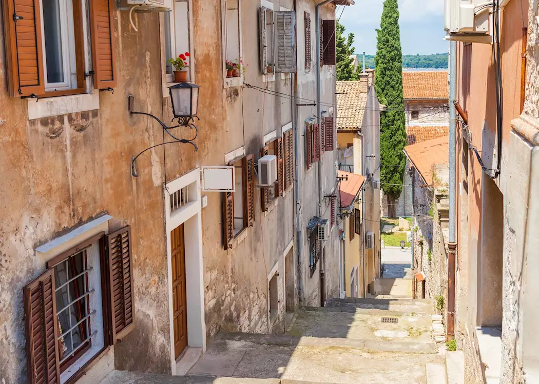 A narrow stone-paved alley in the old town of Bale, Istria, lined with pale stone houses