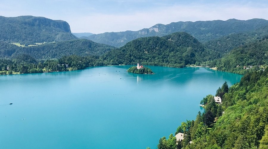 Lake Bled seen from above, with the island church in the middle of the turquoise water