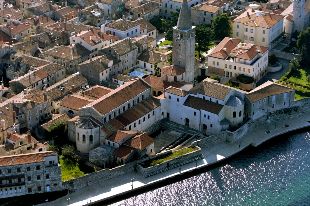Poreč seen from above, red roofs and the bell tower of the Euphrasian Basilica beside the sea